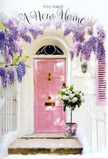 A welcoming Hook doorway is captured at the exact moment it feels like a fresh chapter is beginning. The focal point is a pale pink front door, gently sunlit and framed by softly textured white walls, giving the whole entrance a light, airy charm you might notice while strolling near the village centre. From above, cascades of lavender wisteria spill downward, their loose, tumbling clusters creating a natural archway that feels both romantic and relaxed. Each delicate bloom seems to brush the doorframe, infusing the imagined air with a subtle sweetness and hinting at springtime along the quiet streets of Hook. On the step, right at the threshold, sits a vintage-style grey bucket overflowing with white and cream roses. The roses are plush and fully open, layered petals curling outward as if inviting you closer, interspersed with muted green foliage that softens the arrangement. A soft pink ribbon is tied around the bucket, its tails trailing just enough to suggest movement, and perfectly echoing the colour of the door. Gentle daylight filters through the wisteria, laying painterly shadows across the stone steps and highlighting the round forms of the roses. The entire scene feels like it has been thoughtfully styled by an experienced local florist, perhaps from Flower Delivery Hook, to celebrate a move-in day: understated, tender, and full of hope. Emotionally, it radiates quiet joy, carrying the sense that every petal and leaf is offering good wishes, comfort, and a heartfelt welcome home to whoever is about to cross that doorway.